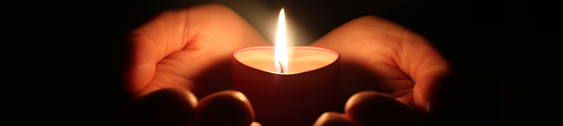Hand holding candle in memorium