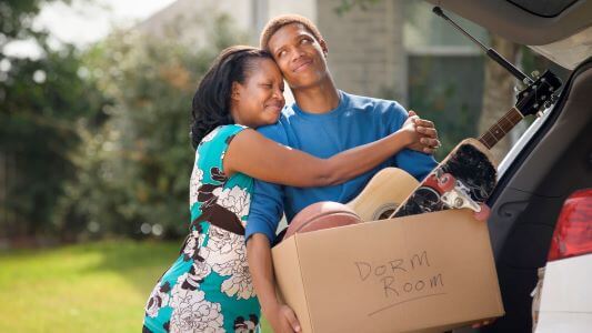 A heartfelt goodbye as a parent helps their child move to a college dorm